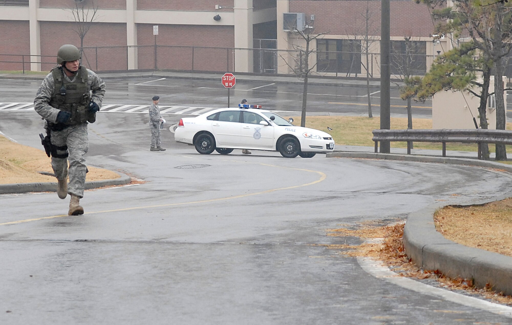 An Airman from the 51st Security Forces Squadron rushes to secure a simulated explosion area during an emergency management exercise here Dec. 10 at Osan Air Base, Republic of Korea. The exercise tested Osan's emergency response to situations and provided valuable training opportunities for the 51st Fighter Wing emergency response agencies. (U.S. Air Force photo/Master Sgt. Marlin Zimmerman)