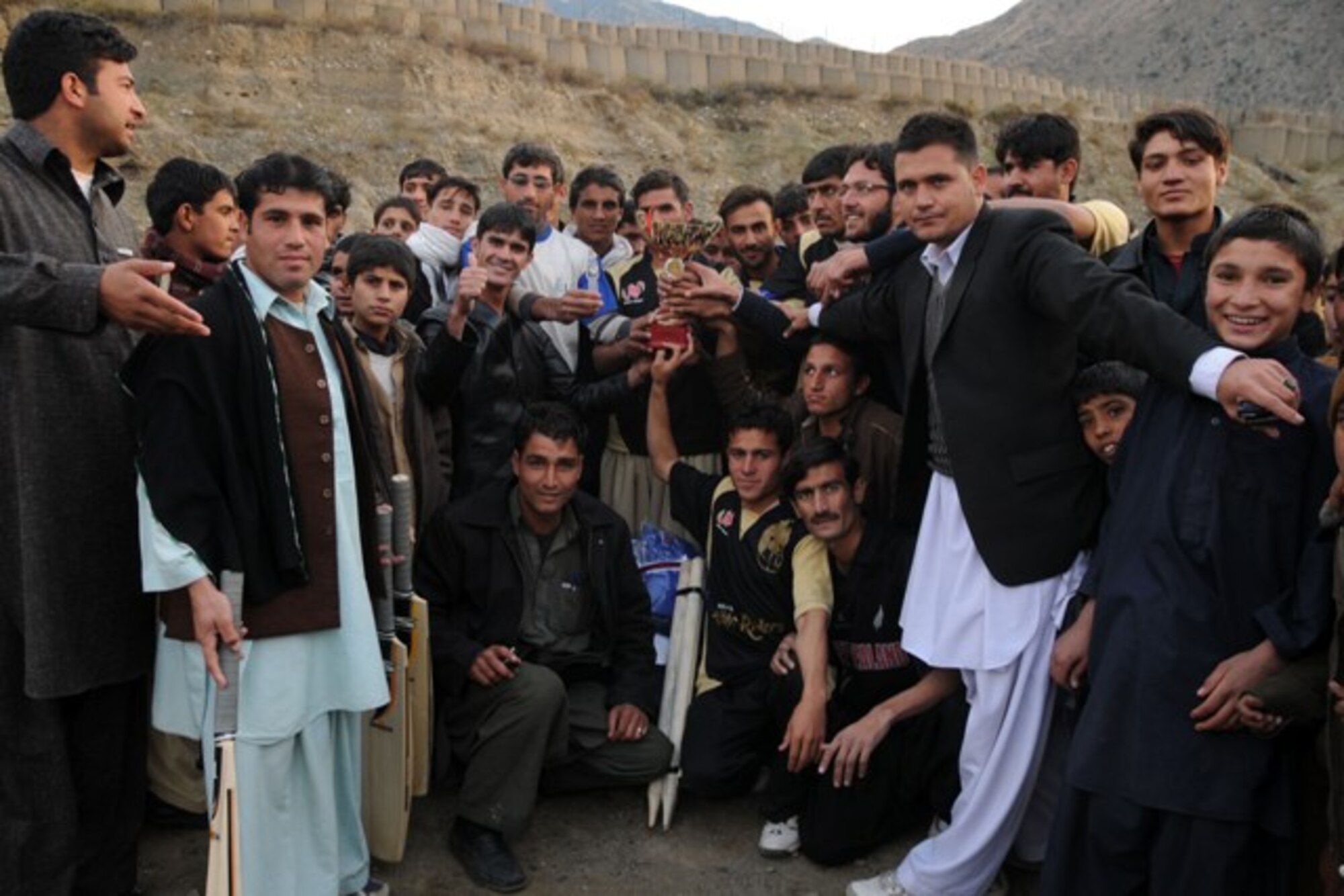 KUNAR PROVINCE, Afghanistan - The Dam Kalay Tigers celebrate their victory after an exhibition cricket match to promote peace and youth sports in Kunar province, Dec. 11. More than 400 adults and children gathered on a cool afternoon in downtown Asadabad, Afghanistan, to watch the Tigers defeat the Kerala Eagles. U.S. Navy Cmdr. Leonard Remias, Kunar Provincial Reconstruction Team commander, said the match was part of the ongoing effort to engage different segments of the population. (U.S. Air Force photo/Tech. Sgt. Brian Boisvert)