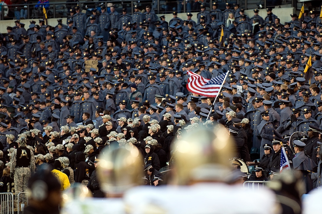 Army servicemembers wave an American flag during the 110th Army-Navy football game at Lincoln Financial Field, Philadelphia, Dec. 12, 2009.