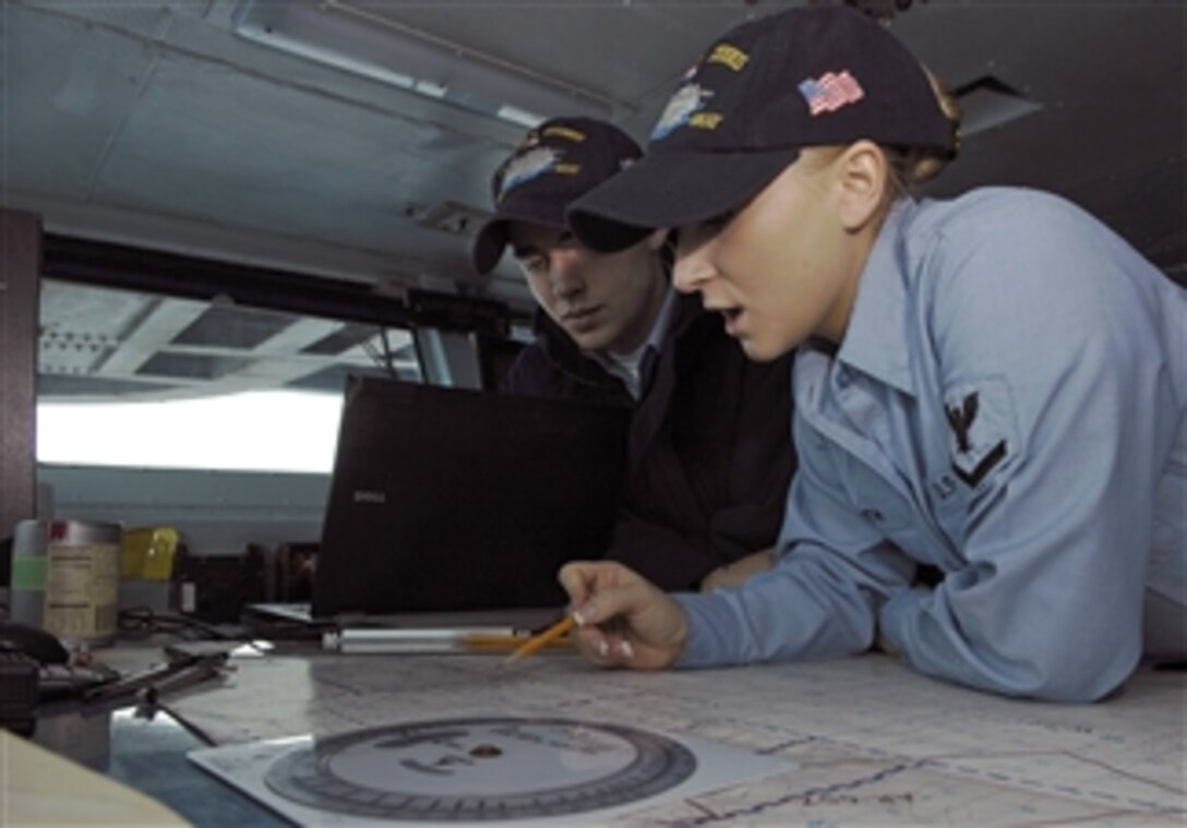 U.S. Navy Petty Officer 3rd Class Jessa Smith (right) trains Seaman Jesse Braman on navigation bearings on the bridge of the aircraft carrier USS John C. Stennis (CVN 74) in the Pacific Ocean on Dec. 9, 2009.  The Stennis is conducting carrier qualifications for fleet replacement squadron pilots off the coast of southern California.  