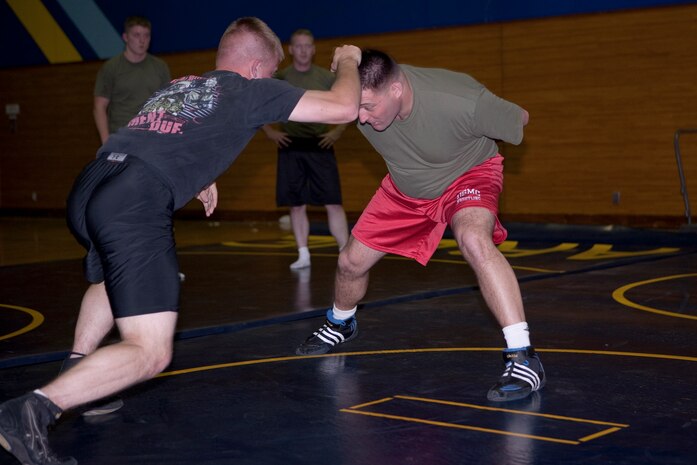 All Marine Wrestling team head coach Joseph Hicks (right) demonstrates the next drill he wants to the see the Marine trying out to perform at IronWorks gym here Dec. 14. Hicks began wrestling when he was 7 years old and made the all Marine team when he tried out as a second lieutenant fresh out of The Basic School.