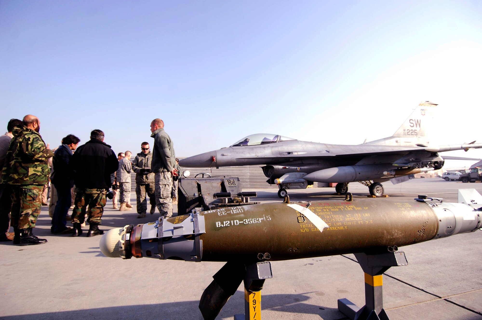 BAGRAM AIRFIELD - Staff Sgt. Sam Arpy a Weapons Load Crew leader and native of Des Moines, Iowa and Airman 1st Class John Ackerman, a Ft. Worth, Texas native brief Afghan National Army Air Corps Brig. Gen. Abdul Wahab Wardak and other officials on the procedures to load a Joint Direct Attack Munition onto an F-16 Fighting Falcon here, Dec. 19, 2009.  Both Airmen are deployed from Shaw Air Force Base, S.C.  (U.S. Air Force photo/Capt. David Faggard)