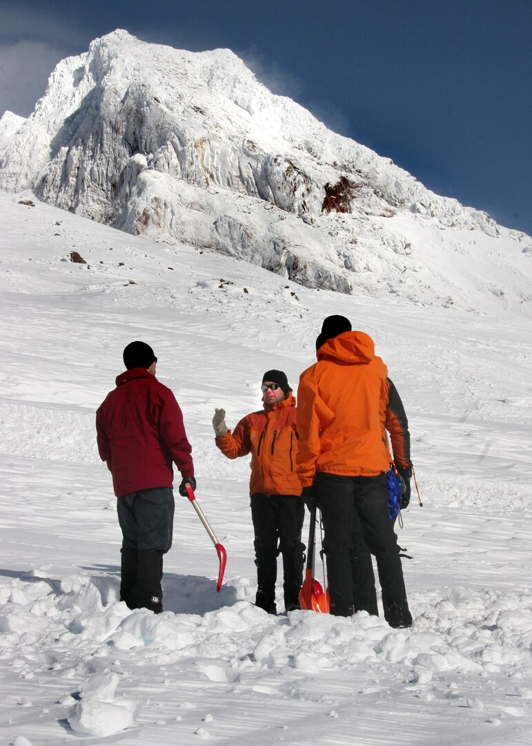 Mt. Hood, Ore. - Air Force Reserve Pararescumen Tech Sgt. Richard Oberstar, Master Sgt. Derrick Brooks, and Staff Sgt. Ian Jameson from the 304th Rescue Squadron stand 7,000 ft. atop Mount Hood December 14, 2009. The three begin to dig an avalache pit as they prepare the area for potential survivors during this search and rescue mission. (U.S. Air Force Photo/Senior Airman Adam Hoffmann)