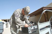 SOUTHWEST ASIA -- Master Sgt. Larry Parker, 64th Expeditionary Support Squadron Communication Flight, repairs and cleans computer hardware outside a dining facility at an undisclosed location Dec. 9. Sergeant Parker, a deployed member from Duke Field's  919th Special Operations WIng, recently updated his unit with more than 70 new computers in support of the mission.  (U.S. Air Force photo/Staff Sgt. Kyle Ray)
