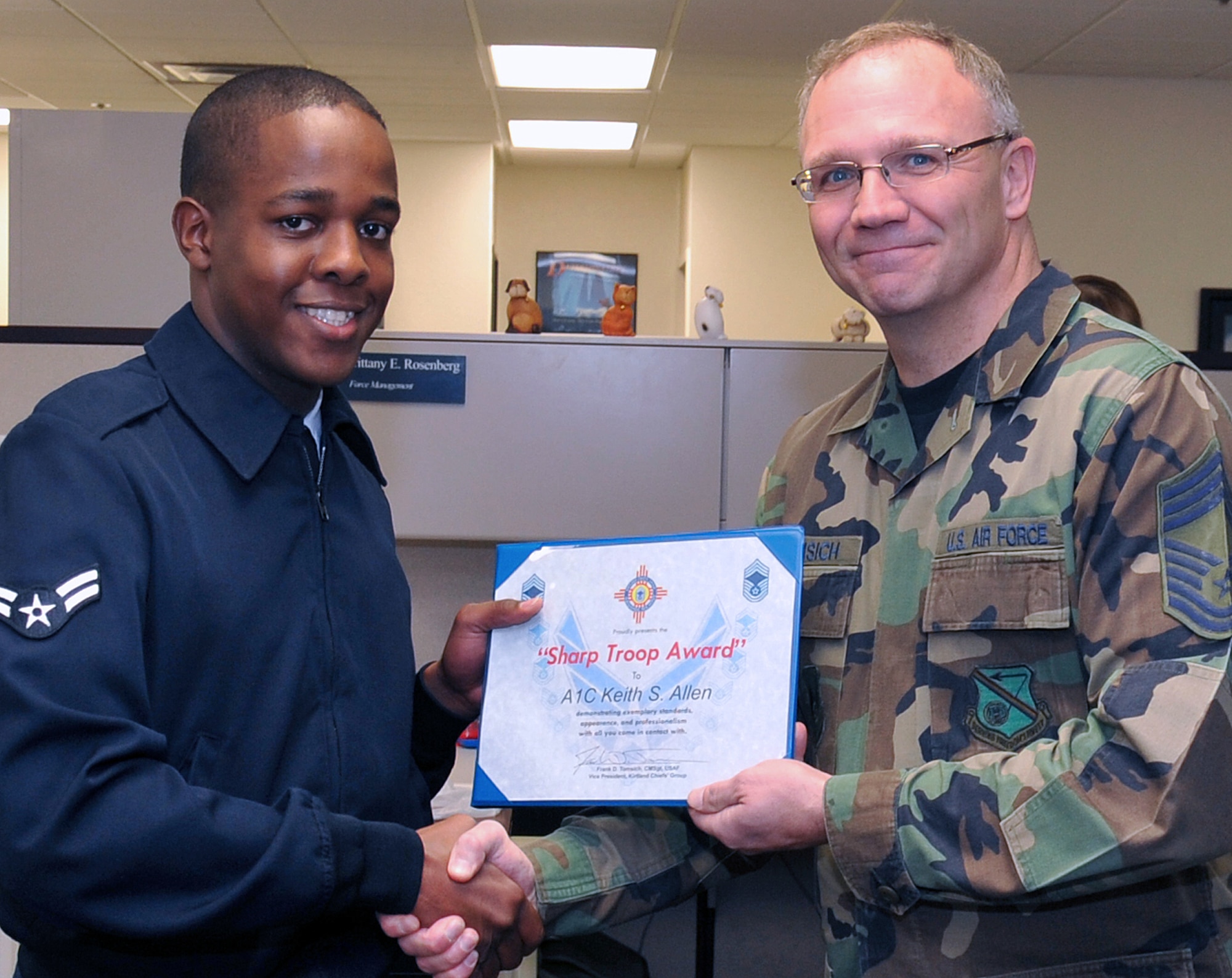 Airman 1st Class Keith Allen, 377th Force Support Squadron, receives a Sharp Troop Award from Chief Master Sgt. Frank Tomsich representing the Kirtland Chiefs? Group. Airman Allen was nominated by Chief Master Sgt. Chuck Crisler, 377th Mission Support Group, for his professionalism and dedication. U.S. Air Force photo by Todd Berenger
