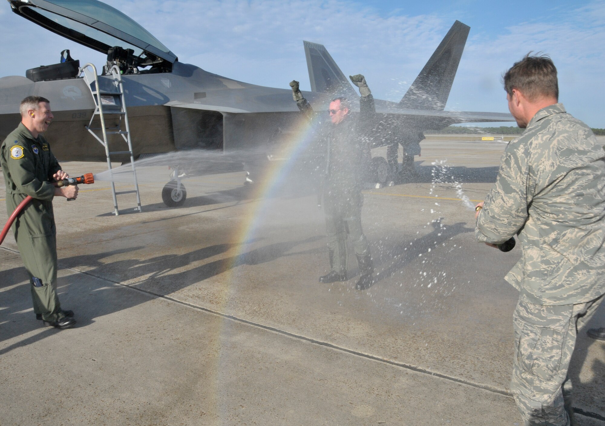 Lt. Col. Steven Burgh, 2nd Fighter Squadron Commander, and Col. Michael Fleck, 325th Mission Support Group Commander spray Brig. Gen. Darryl Roberson, 325th Fighter Wing Commander in celebration of his fini flight in the F-22 Dec. 10. (U.S. Air Force photo Lisa Norman)