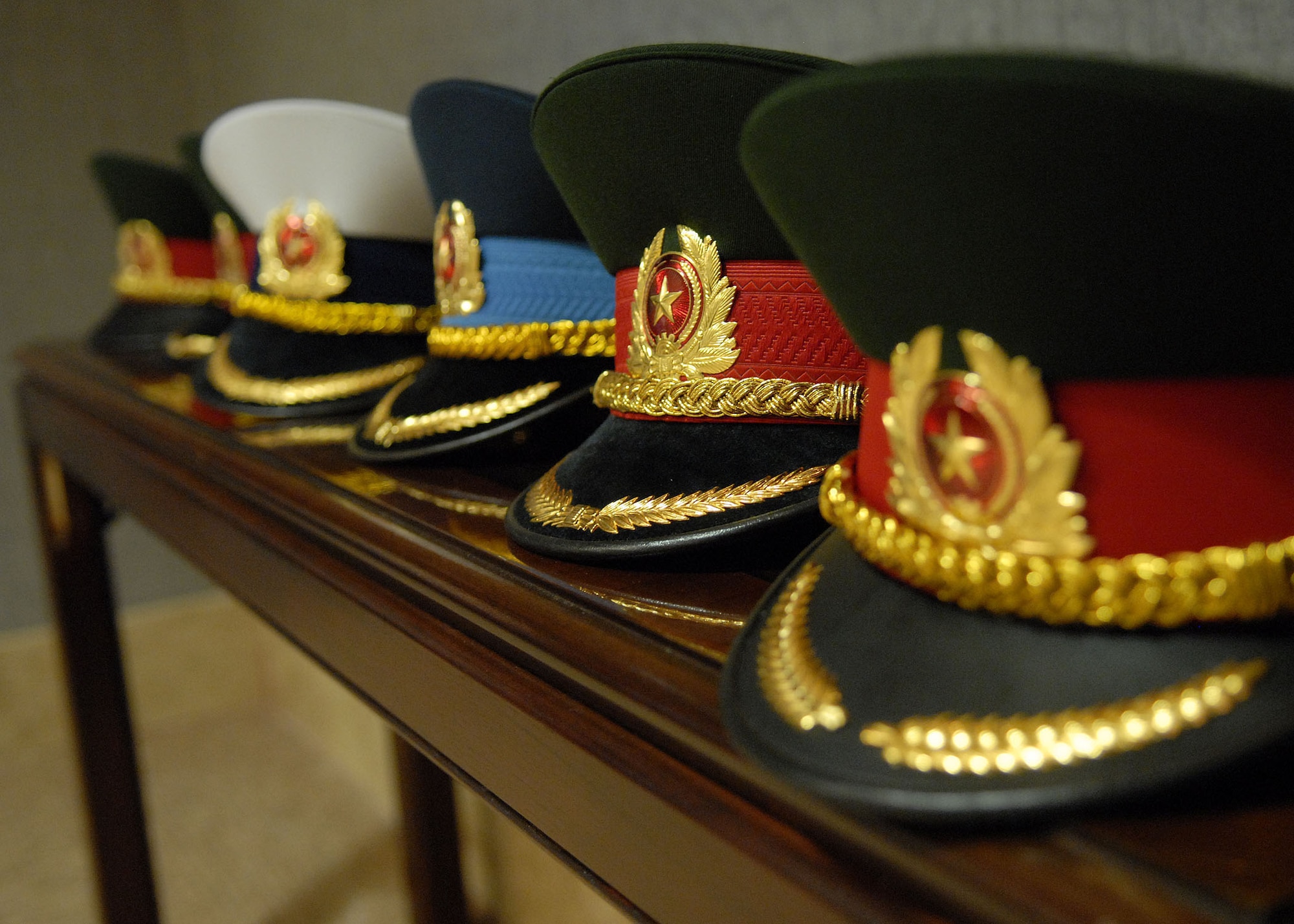 Vietnamese flag officers service dress hats sitting at the Falcon Conference Room, at headquarters, Pacific Air Forces, during a briefing and tour of Hickam Air Force Base, Hawaii, on Dec. 11. (U.S. Air Force photo/ Tech. Sgt. Jerome S. Tayborn)