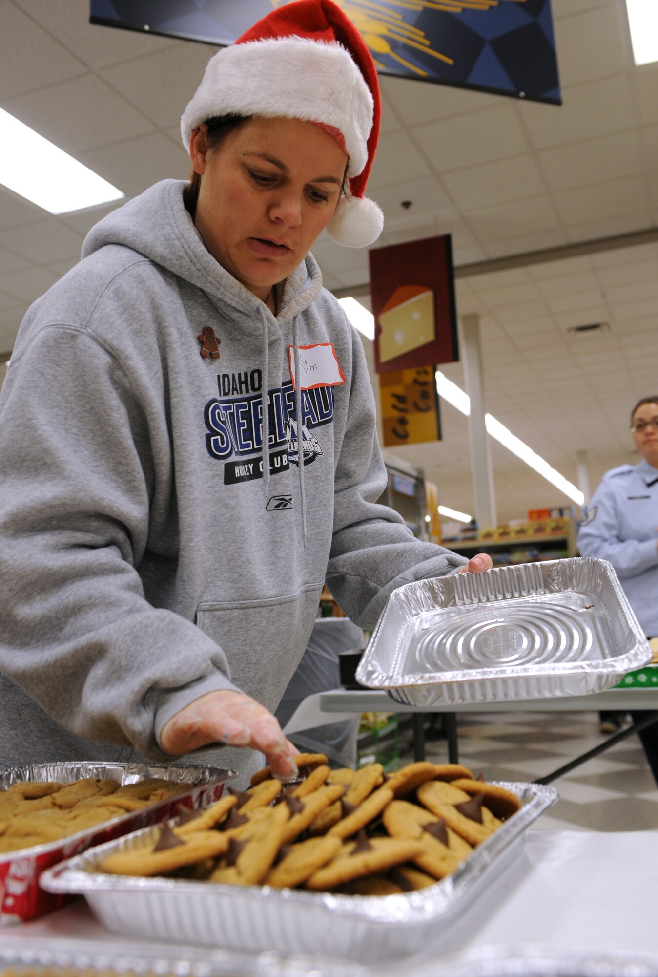 MOUNTAIN HOME AIR FORCE BASE, Idaho -- Kim Ulmer places cookies in a container as she prepares to package cookies during the annual cookie drive at the commissary Dec. 7. The 366th Fighter Wing's Annual Holiday Cookie Drive takes place during the first part of December to provide the base’s dorm residents a comforting taste of home in the form of a dozen cookies. (U.S. Air Force photo by Airman 1st Class Debbie Lockhart)
