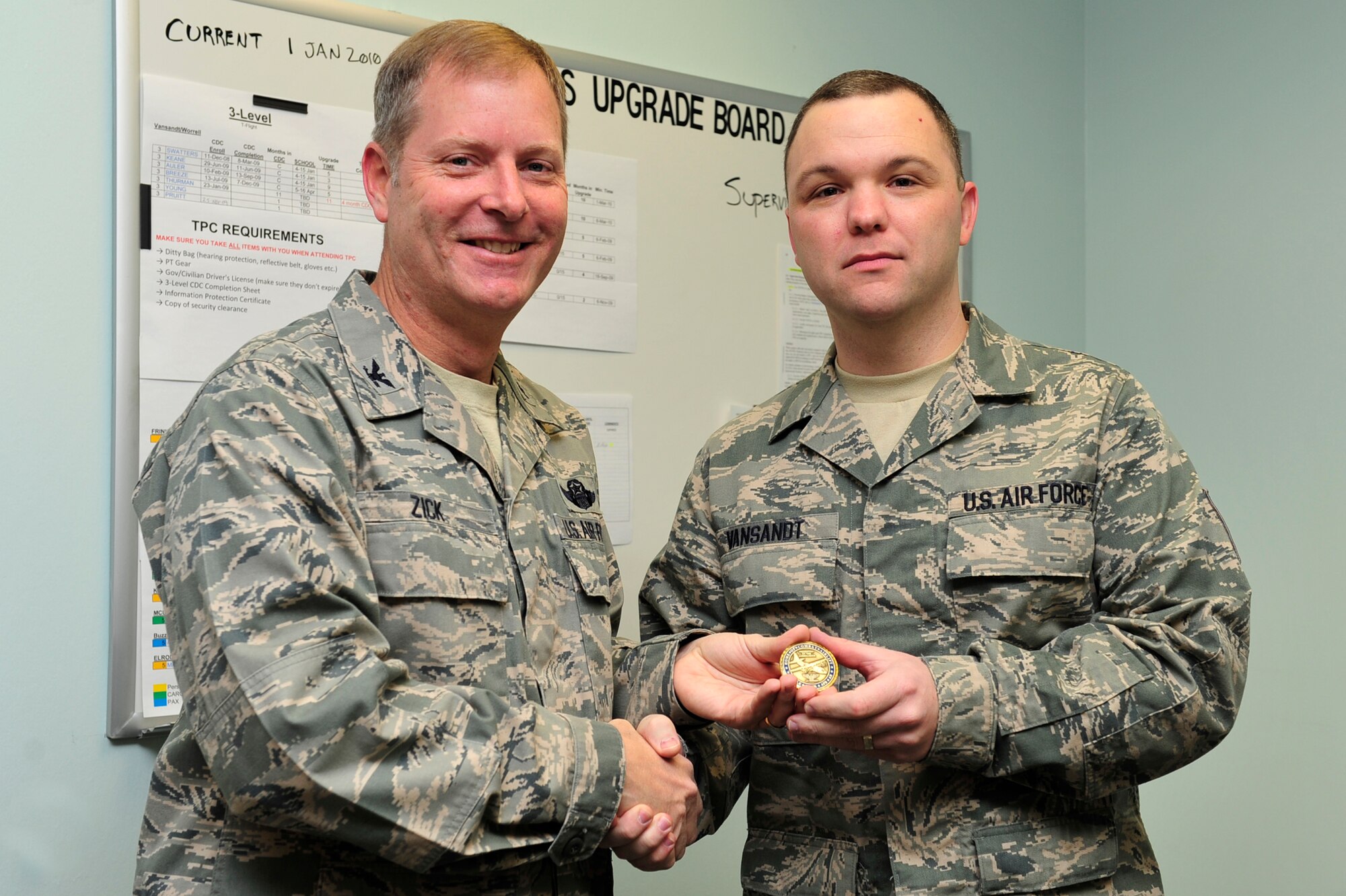Col. Michael Zick, 19th Airlift Wing vice commander, presents Master Sgt. Jonathan Vansandt, 96th Aerial Port Squadron unit education and training manager, a commander's coin Dec. 15 for being chosen as the Combat Airlifter of the week. Sergeant Vansandt facilitated end-of-course exams and testing for 129 members to meet Air Force timelines and goals. He also led training processes that helped prepare 40 members for deployment to Iraq supporting Operation Iraqi Freedom. (U.S. Air Force Photo by Airman 1st Class Lausanne Pacheco)