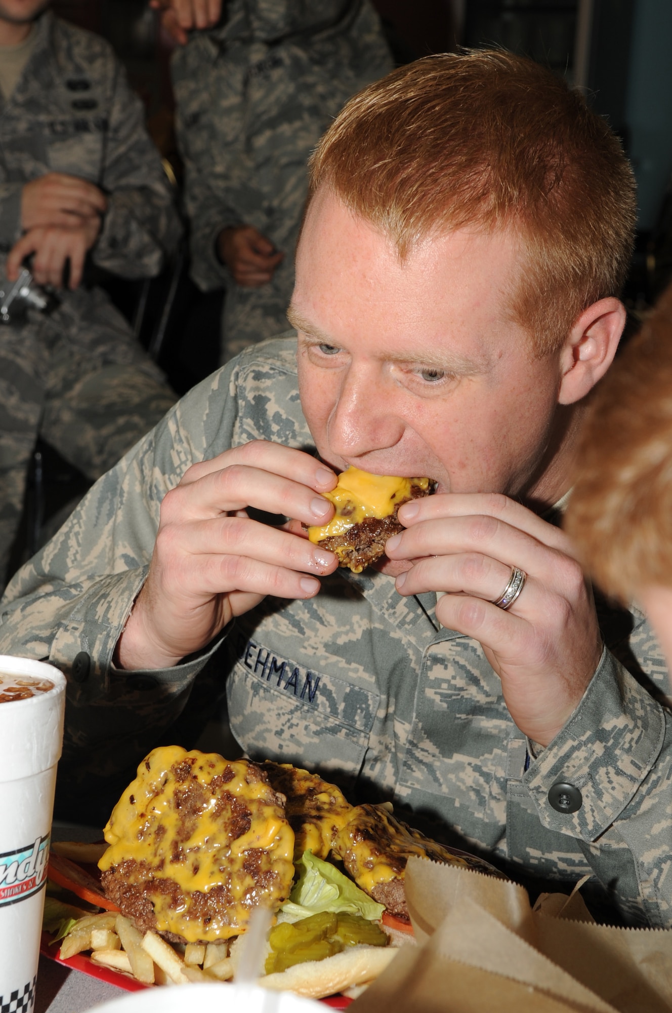 Capt. Jeremy Gehman, 4th Fighter Wing chief of general law, devours a hamburger patty during the "Big 'A' Challenge" at Andy's Cheesesteaks and Cheeseburgers in Goldsboro, N.C., Dec. 15, 2009. To complete the challenge, the participants must eat a six-patty burger with all of the fixings, french fries and a drink within 30 minutes. Capt. Gehman hails from Pensacola, Fla. (U.S. Air Force photo/Staff Sgt. Courtney Richardson)