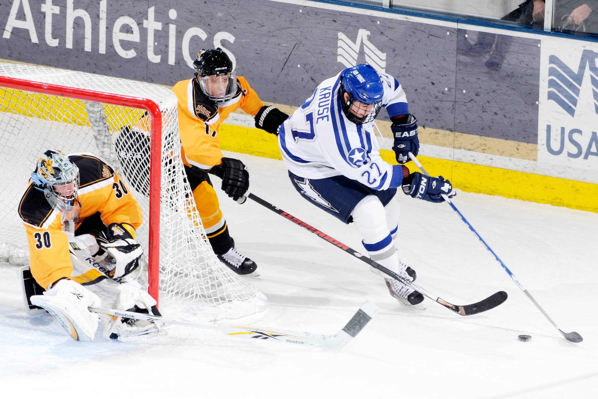 U.S. Air Force Academy freshman forward John Kruse moves the puck around the goal during the first period of the Falcon's game against American International College at the Cadet Ice Arena Dec. 5, 2009.  Air Force defeated AIC 6-2, sweeping the series with a 5-3 win Dec. 4. (U.S. Air Force photo/J. Rachel Spencer)