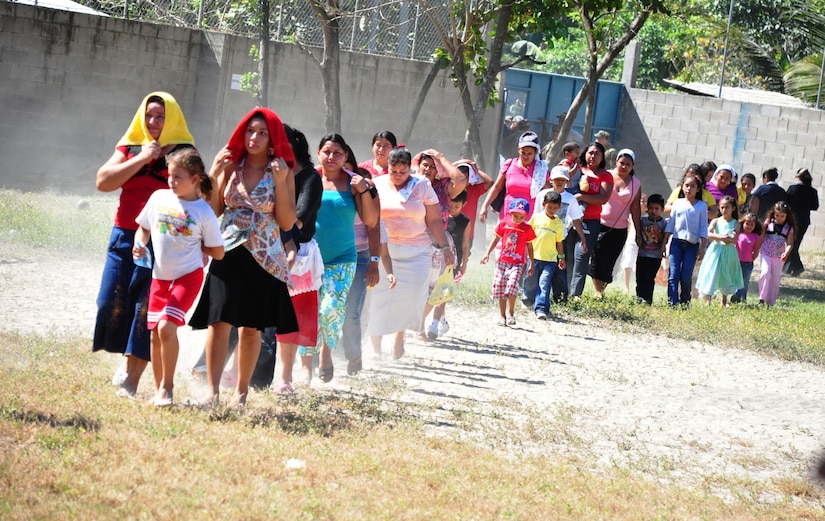 Residents of El Achiotal, a community affected by November flooding and mudslides in El Salvador, enter the schoolyard where a Medical Civil Action Program (MEDCAP) was in session Dec. 15, 2009. The two-day medical mission offered residents the opportunity to receive medical care, immunizations, education, and prescription drugs free of charge. It was a combined effort between the Salvadoran government, the U.S. Embassy in El Salvador, and U.S. Southern Command’s Joint Task Force-Bravo – based at Soto Cano Air Base, Honduras. More than 1,300 patients were seen in the two days. (U.S. Air Force photo/Tech. Sgt. Mike Hammond)