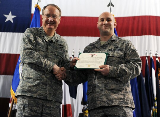 MINOT AIR FORCE BASE, N.D. -- Lt. Gen. Frank Klotz, Air Force Global Strike Command commander, awards the bronze star to Senior Airman Gary Conlee, 91st Security Support Squadron travel control center control technician, during an all-call Dec. 2 here. Airman Conlee was recently awarded the medal for meritorious service with the 855th Air Expeditionary Wing at Bagram Air Base, Afghanistan. (U.S. Air Force photo by Staff Sgt. Stacy Moless)