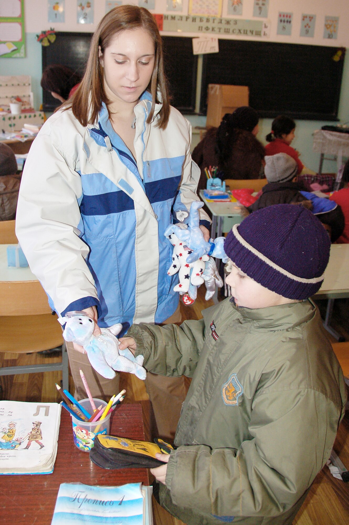 Senior Airman Amy Poch hands a teddy bear to a Nizhanchuisk Orphanage and School student during a visit in December. Airmen from the Transit Center at Manas, Kyrgyzstan delivered over 50 donated boxes of clothes, toys and necessities from the U.S., to the orphanage. Airman Poch is a 376th Expeditionary Medical Group laboratory technician. (U.S. Air Force photo/Staff Sgt. Olufemi Owolabi)