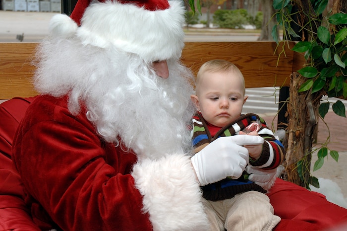 Jackson White gets a candy cane while sitting on Santa's lap during the youth holiday party at the Youth Programs Center here Dec. 12, 2009. Charleston Air Force Base youths had the opportunity to play games, decorate cupcakes, scale a wall, sit on Santa's lap and enjoy arts and crafts during the annual holiday party. Jackson is the son of U.S. Air Force Maj. Tara White, 437th Force Support Squadron commander. (U.S. Air Force photo/Staff Sgt. Marie Brown)