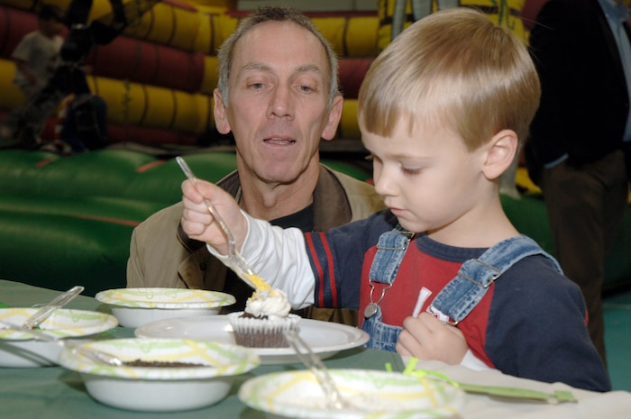 Gary Grove watches as his son Noah decorates a cupcake during the youth holiday party at the Youth Programs Center here Dec. 12, 2009. Charleston Air Force Base youths had the opportunity to play games, decorate cupcakes, scale a wall, sit on Santa's lap and enjoy arts and crafts during the annual holiday party. Mr. Grove is a marketing specialist with the 437th Force Support Squadron. (U.S. Air Force photo/Staff Sgt. Marie Brown)