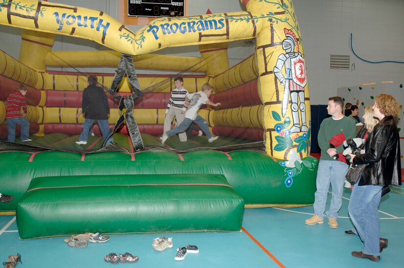Parents watch as their kids jump around in the bounce castle during the youth holiday party at the Youth Programs Center here Dec. 12, 2009. Charleston Air Force Base youths had the opportunity to play games, decorate cupcakes, scale a wall, sit on Santa's lap and enjoy arts and crafts during the annual holiday party. The Youth Programs Center staff offer many services to enhance the lives of Team Charleston families and work to reinforce the Air Force priority of taking care of families during the Year of the Air Force Family. (U.S. Air Force photo/Staff Sgt. Marie Brown)
