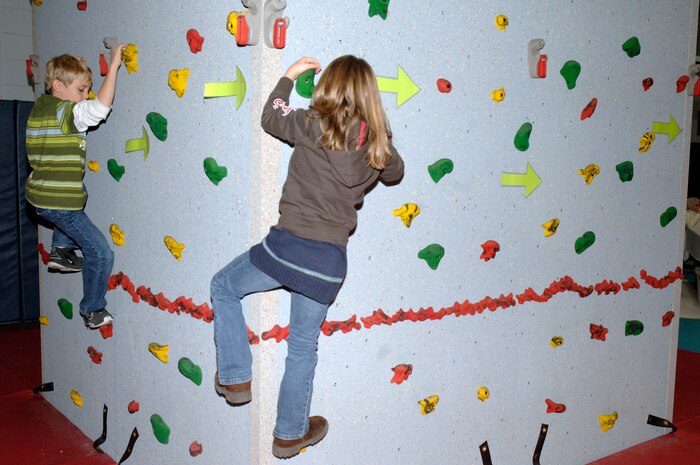Keelan Lynch, left, and Kaitlyn Lynch, right, scale a wall during the youth holiday party at the Youth Programs Center here Dec. 12, 2009. Charleston Air Force Base youths had the opportunity to play games, decorate cupcakes, scale a wall, sit on Santa's lap and enjoy arts and crafts during the annual holiday party. Keelan and Kaitlyn are the children of U.S. Air Force Tech. Sgt. Amanda Lynch who is with the 373rd Training Squadron, Detachment 5. (U.S. Air Force photo/Staff Sgt. Marie Brown)