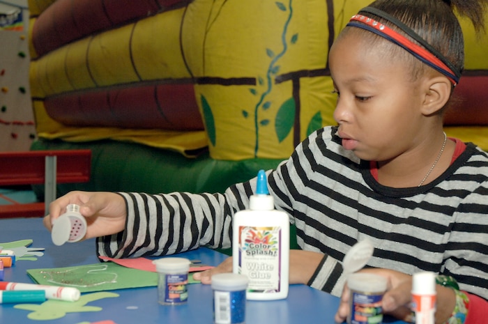 Kiontay Tillis decorates a holiday paper ornament during the youth holiday party at the Youth Programs Center here Dec. 12, 2009. Charleston Air Force Base youths had the opportunity to play games, decorate cupcakes, scale a wall, sit on Santa's lap and enjoy arts and crafts during the annual holiday party. Kiontay is the daughter of Dominique Tillis who works at Youth Programs Center. (U.S. Air Force photo/Staff Sgt. Marie Brown)