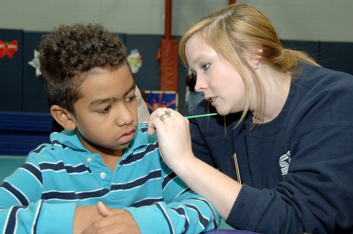 Marcus Pearson waits as Hannah Jones paints something festive on his face during the youth holiday party at the Youth Programs Center here Dec. 12, 2009. Charleston Air Force Base youths had the opportunity to play games, decorate cupcakes, scale a wall, sit on Santa's lap and enjoy arts and crafts during the annual holiday party. Ms. Jones is the wife of U.S. Air Force Airman 1st Class Michael Jones who is with the 437th Logistics Readiness Squadron and Marcus is the son of U.S. Air Force Staff Sgt. Marcus Pearson who is also with the 437 LRS. (U.S. Air Force photo/Staff Sgt. Marie Brown)