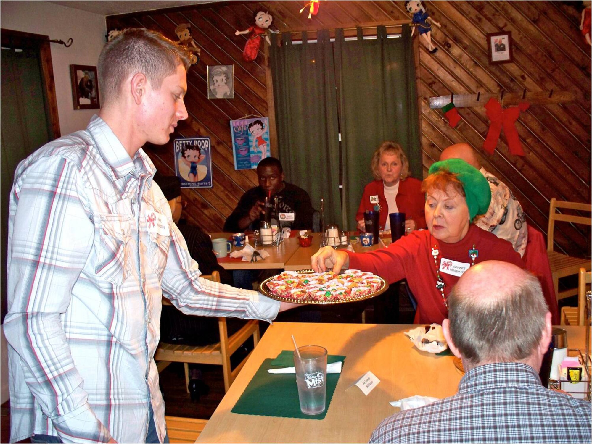 ALAMOGORDO, N.M. -- Airman 1st Class Paul Manion, 849th Aircraft Maintenance Squadron, gets to know Connie Rosemeyer and offers her an appetizer at the Alamogordo Retired E-9ers Adopt an Airman program holiday dinner at a local restaurant here Dec. 5. By signing up for the Adopt an Airman program, people in the local community are given the names of two Airmen to "adopt." They make the initial contact and host the Airmen for a dinner where they can get to know each other. (Courtesy photo)