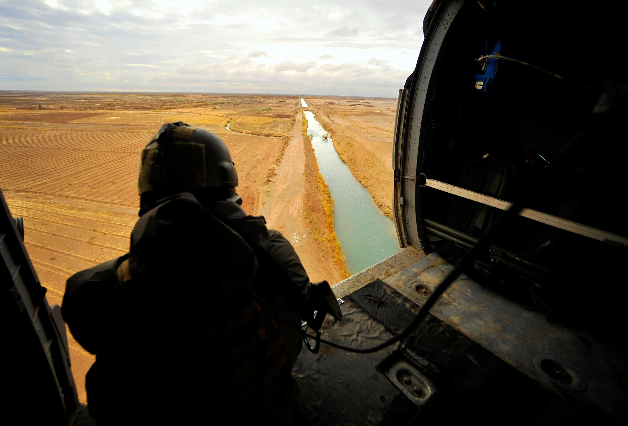 A pararescueman looks out the door of an HH-60G Pave Hawk while on the way to pick up a patient Dec. 8, 2009. The members of the 66th Expeditionary Rescue Squadron can respond to medical evacuations in less than seven minutes to pick up patients in need of care. The pararescueman is assigned to the 66th Expeditionary Rescue Squadron. (U.S. Air Force photo/Staff Sgt. Angelita Lawrence) 