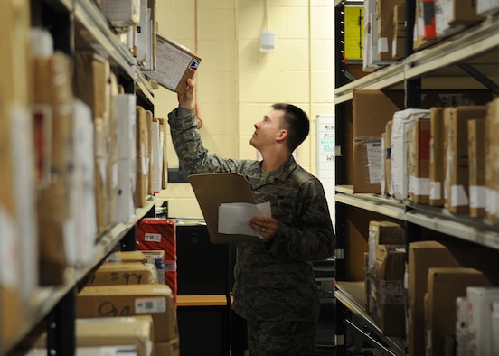 RAF MILDENHALL, England – Airman 1st Class Ronald Brandtman , 100th Communication Squadron airfield systems technician, locates a customer’s package while volunteering at the pick-up window at the military post office Dec. 15. The post office is accepting volunteers to help with the holiday postal rush; day and night shifts are available. For more information contact the post office at DSN 238-5159 for further details. (U.S. Air Force photo/ Staff Sgt. Jerry Fleshman)