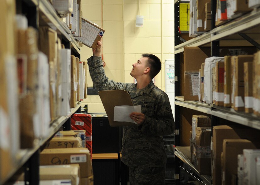 RAF MILDENHALL, England – Airman 1st Class Ronald Brandtman , 100th Communication Squadron airfield systems technician, locates a customer’s package while volunteering at the pick-up window at the military post office Dec. 15. The post office is accepting volunteers to help with the holiday postal rush; day and night shifts are available. For more information contact the post office at DSN 238-5159 for further details. (U.S. Air Force photo/ Staff Sgt. Jerry Fleshman)