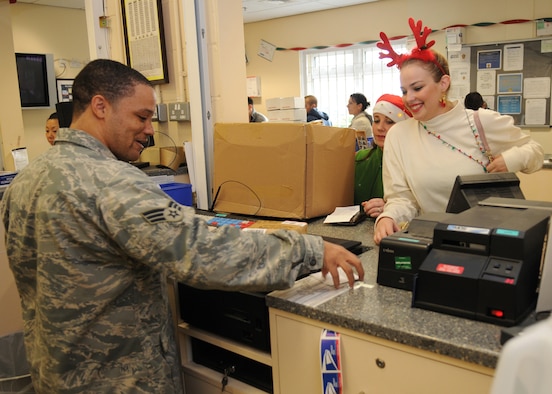 RAF MILDENHALL, England – Senior Airman Denny Williams, 100th Communication Squadron postal clerk, assists Marissa Nunnes and Alex House with an outgoing package at the RAF Mildenhall Post Office Dec. 15. The post office will be providing extended hours during the holiday season. Outgoing mail will be open from 8:30 a.m. to 5 p.m. Monday through Friday and 9 a.m. to 1 p.m. Saturday. The pick-up window hours are 8 a.m. to 6 p.m Monday through Friday and 9 a.m to 1 p.m. Saturday. The post office will resume normal business hours Dec. 28. (U.S. Air Force photo/ Staff Sgt. Jerry Fleshman)
