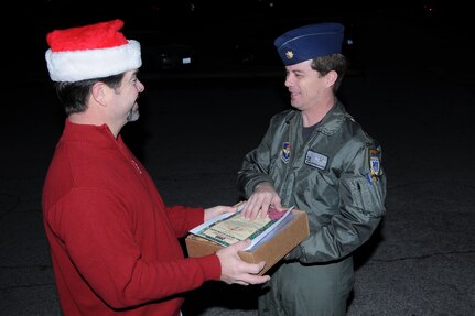 Maj. Kevin McGaughey, 559th Flying Training Squadron, delivers Christmas cookies to a volunteer at the Chapel Center Dec. 15 in support of the annual Cookie Crunch Drive.  (U S Air Force Photo/Don Lindsey)