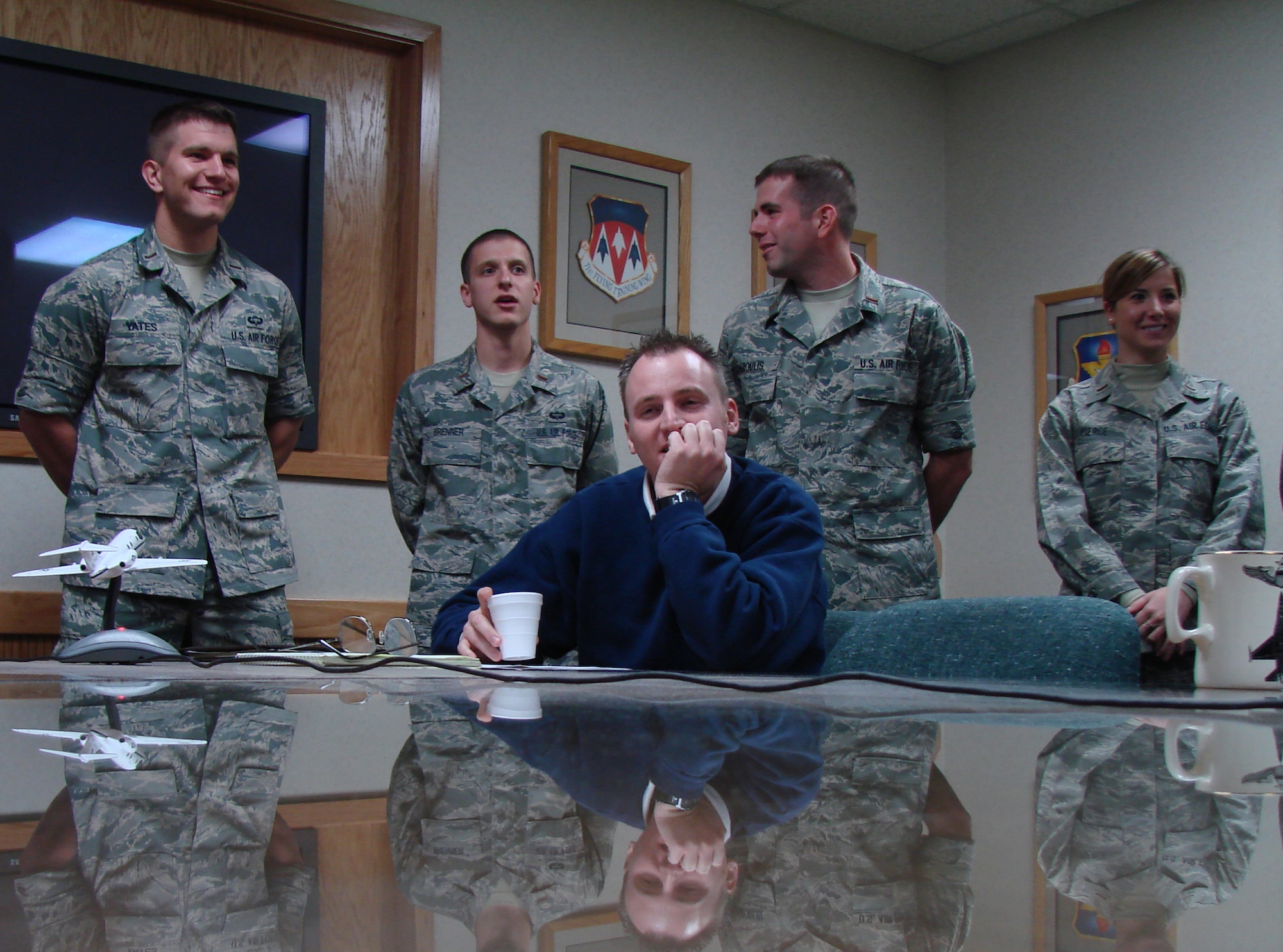 Audio Visual Specialist Chad Chambers calculates camera logistics as members
of "Team Wolf Pack," 2nd Lts. John Yates, Scott Brenner and Cari Pierce,
present their Joint Specialized Undergraduate Pilot Training graduation
dinner video concepts to 71st Flying Training Wing leadership Dec. 4. Two
teams of five competed with each other to create the most compelling concept
in a project launched by Col. Chris Nowland, 71st FTW commander, styled
after NBC's 'The Apprentice' television series.