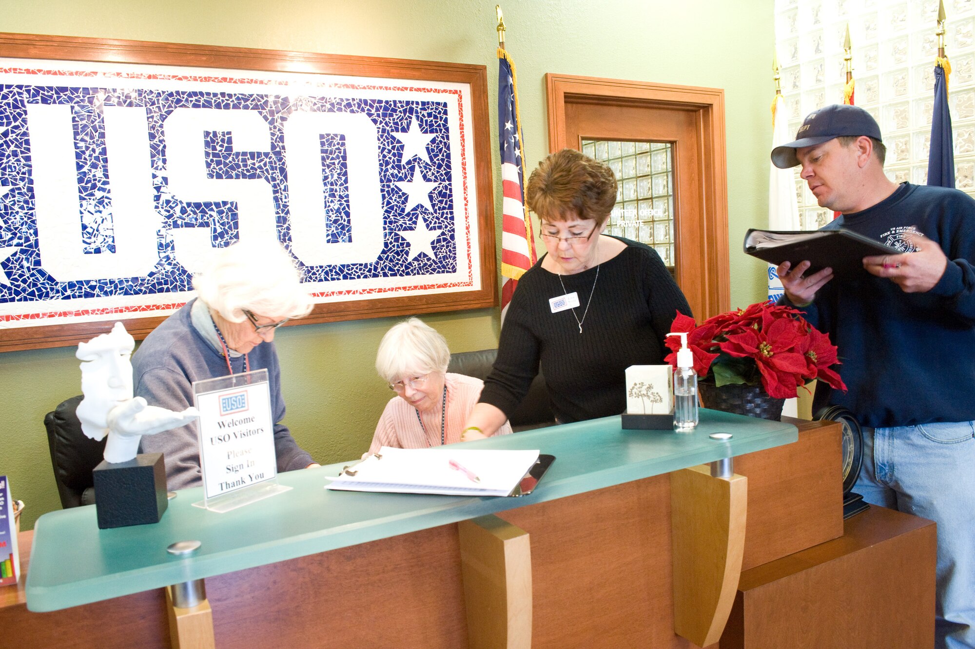 Volunteers at the United Service Organization lounge review paperwork Dec. 11. The USO lounge is open to all Department of Defense ID card holders and offers many amenities to help Airmen and their families relax. (U.S. Air Force photo/Brianne Zimny)