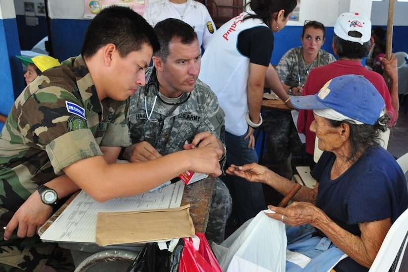 U.S. Army Maj. David Haight (center) and a translator from the El Salvadoran military evaluate an elderly woman seeking treatment during a Medical Civil Action Program (MEDCAP) conducted by the Salvadoran Ministry of Health and Joint Task Force-Bravo, in San Agustin, El Salvador, Dec. 14, 2009. The MEDCAP, which continues tomorrow in El Achiotal, El Salvador, comes as a follow-up to earlier medical and relief efforts coordinated with the Ministry of Health, U.S. Southern Command, and the U.S. Embassy and Military Group in El Salvador. November flooding and mudslides killed more than 100 people and displaced many more in the area. (U.S. Air Force photo/Tech. Sgt. Mike Hammond)