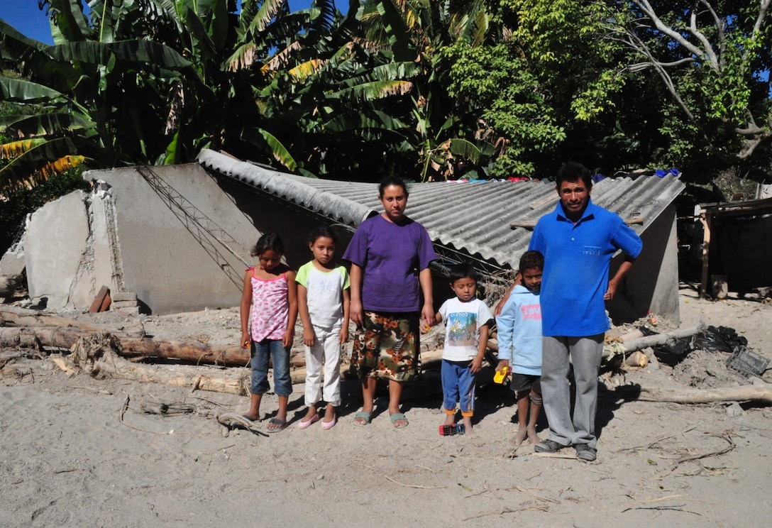Members of the Hernandez family gather in front of the remains of Carla Hernandez’ home in San Agustin, El Salvador, Dec. 14, 2009. November flooding and mudslides claimed more than 100 lives and displaced many more residents. A combined Medical Civil Action Program (MEDCAP) coordinated between U.S. and El Salvadoran officials is providing free medical care to residents of affected areas today and tomorrow. A team of 30 from Joint Task Force-Bravo, based in Honduras, is working with the Salvadoran Ministry of Health and others to provide the care. (U.S. Air Force photo/Tech. Sgt. Mike Hammond)