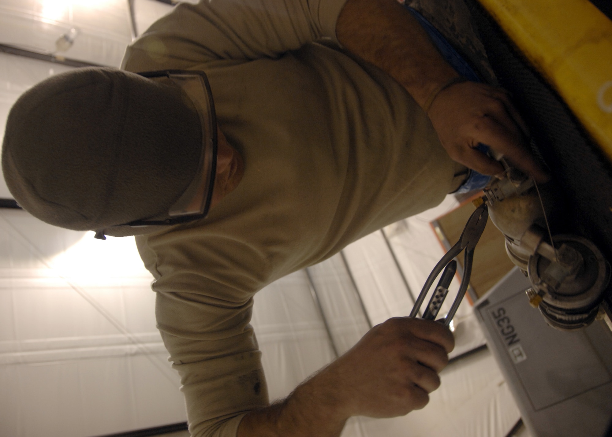 KANDAHAR AIRFIELD, Afghanistan -- Airman 1st Class Jake Gallet safety wires the accumulator servicing valve Dec. 10, 2009. Safety wire ensures the bolts will not loosen during flight due to vibrations. Airman Gallet is a crew chief with the 451st Expeditionary Maintenance Squadron Maintenance Flight from Davis-Monthan Air Force Base, Ariz. (U.S. Air Force photo/Senior Airman Timothy Taylor)