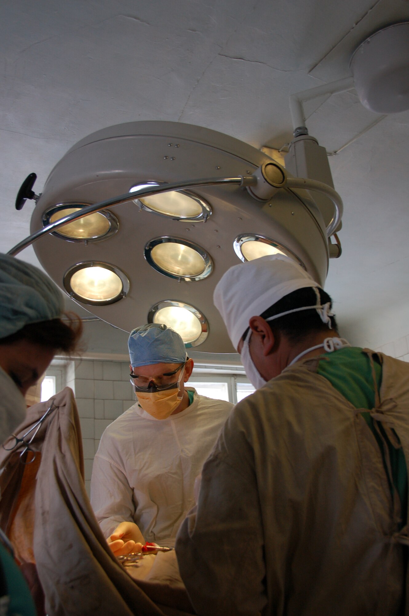 TRANSIT CENTER AT MANAS, Kyrgyzstan – Lt. Col. Joseph Brown, 376th Expeditionary Medical Group, assists in performing a surgical operation with a Kyrgyz surgeon during a joint medical operation at a Kyrgyz Republic military hospital Dec. 11, 2009.  A team of Airmen visited the hospital and performed two separate procedures. The joint operations were part of an ongoing partnership between medical Airmen at the Transit Center and their counterparts at the Besh-Kungei Military Hospital. (U.S. Air Force photo/Staff Sgt. Olufemi Owolabi)