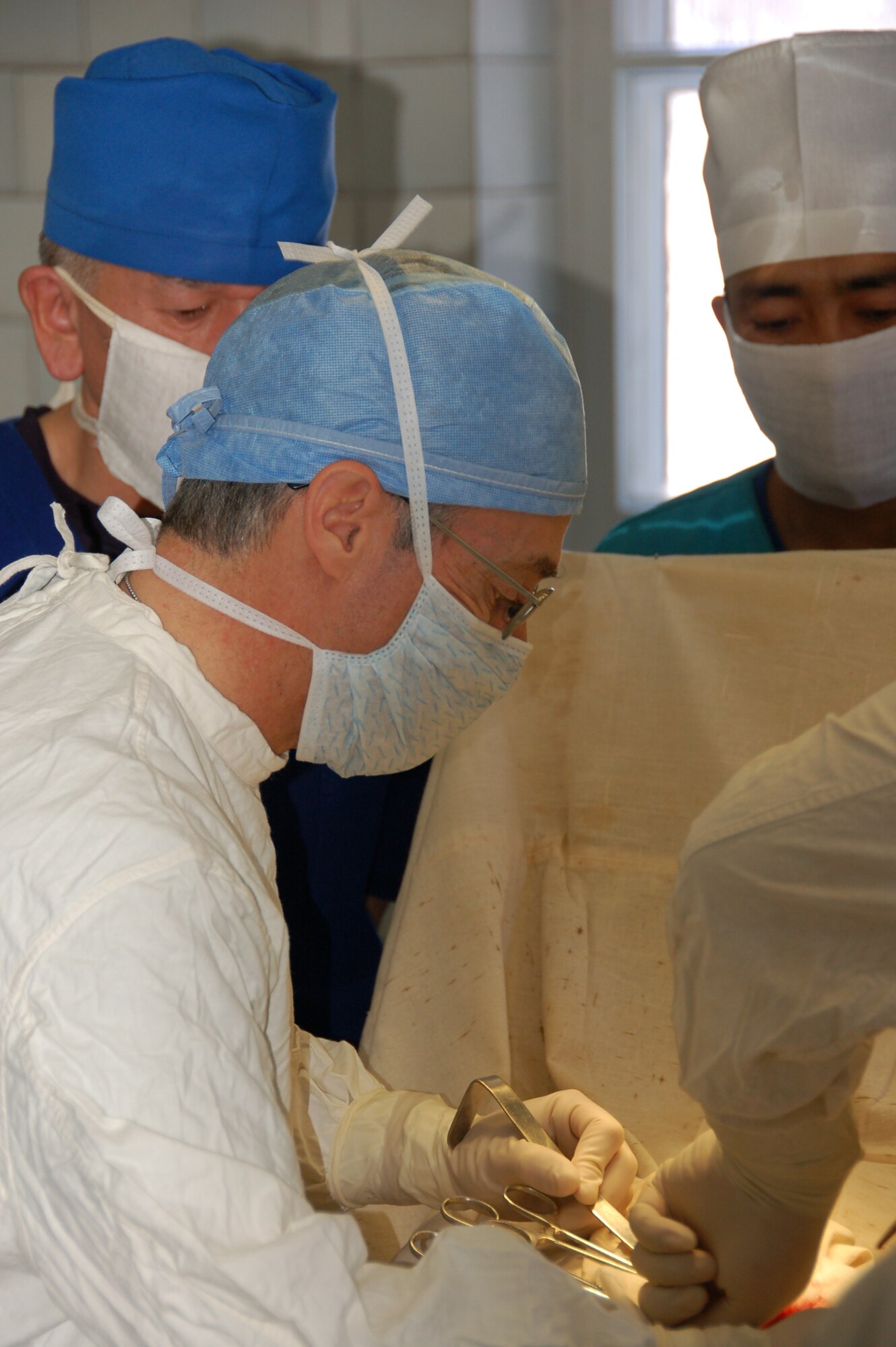 TRANSIT CENTER AT MANAS, Kyrgyzstan – Col. Jerrold Flyer performs a surgery with a Kyrgyz surgeon during a joint medical operation at a Kyrgyz Republic military hospital in Kyrgyzstan Dec. 11, 2009.  A team of Airmen visited the hospital and performed two separate surgical operations. The joint procedures were part of an ongoing partnership between medical Airmen at the Transit Center and their counterparts at the Besh-Kungei Hospital. Colonel Flyer is the commander of the 376th Expeditionary Medical Group. (U.S. Air Force photo/Staff Sgt. Olufemi Owolabi)