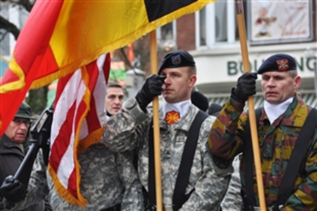 U.S. Army Sgt. Brandon McIntosh, left, carries the U.S. Flag and Adjudant Chief Henri Plessiet, a Belgian solider, carries the Belgian flag with the U.S. Army Garrison Benelux Color Guard during the Battle of the Bulge anniversary parade in Bastogne, Belgium, Dec. 12, 2009. Plessiet is the first soldier from the Belgian 1st Field Artillery Regiment to carry his nation's flag.