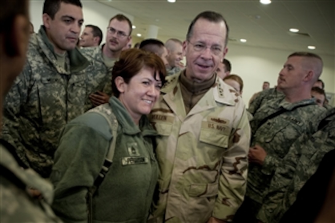 Chairman of the Joint Chiefs of Staff Adm. Mike Mullen, U.S. Navy, poses for photos with soldiers in Kabul, Afghanistan, on the 2009 USO Holiday Troop Visit on Dec. 14, 2009.  Mullen and his wife Deborah welcomed tennis star Anna Kournikova, comedian Dave Attell, tennis coach Nicholas Bollettiere and musician Billy Ray Cyrus on the tour visiting troops in Afghanistan, Iraq and Germany.  