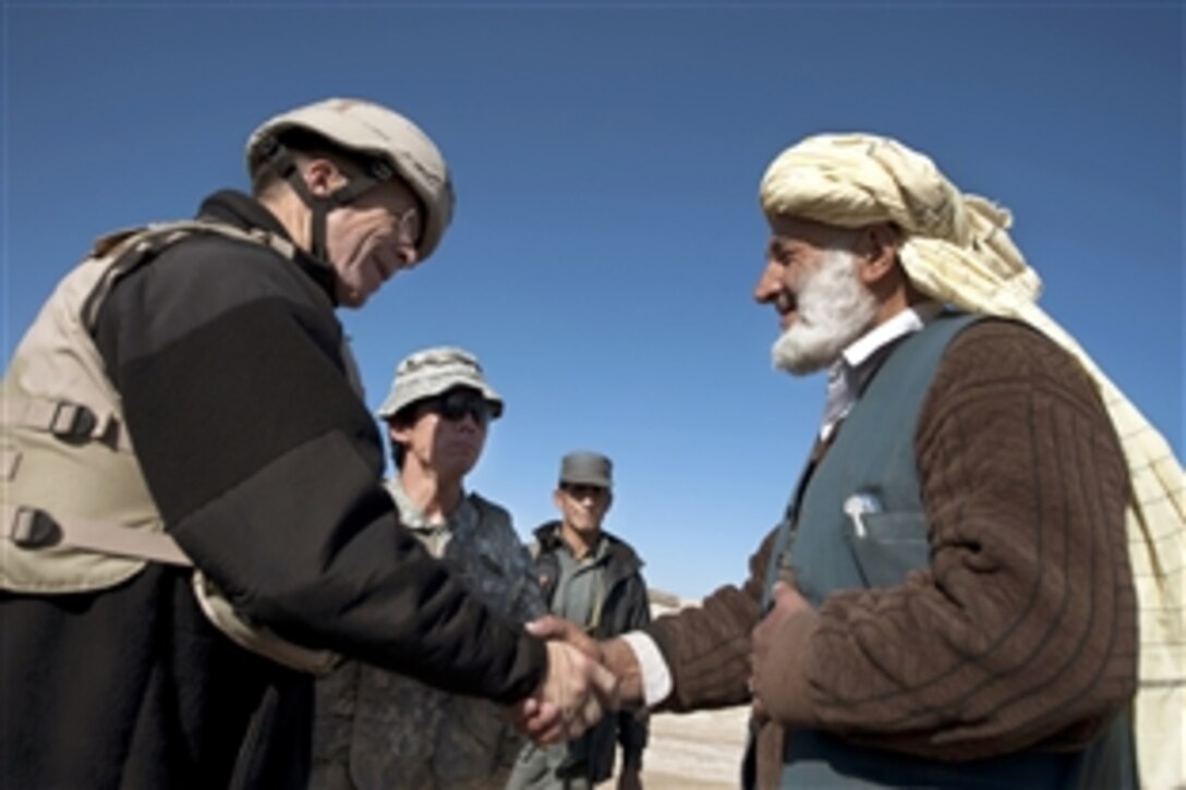 U.S. Navy Adm. Mike Mullen, chairman of the Joint Chiefs of Staff, greets Shir Kham, village elder, in Mata Khan, Afghanistan, Dec. 15, 2009. Mullen toured the village market and discussed the security situation with the elder during his visit to Paktika province.