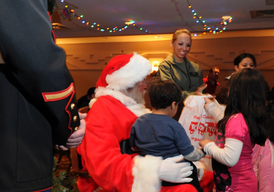 Sgt. Deborah L. Myatt, an aerial observer with Marine Medium Helicopter Squadron 764, hands a child a gift during a Toys for Tots holiday party Dec. 15, 2009, in Tusayan, Ariz., located just south of the Grand Canyon. The party, organized by Northern Arizona Toys for Tots and the Marine Corps League, was held for families in the area. Earlier in the day, the reserve squadron, based at Edwards Air Force Base north of Los Angeles, airlifted donated toys and food to Supai, Ariz., a village within the Grand Canyon and the home of the Havasupai tribe. Myatt, 25, is a native of Lancaster, Calif.