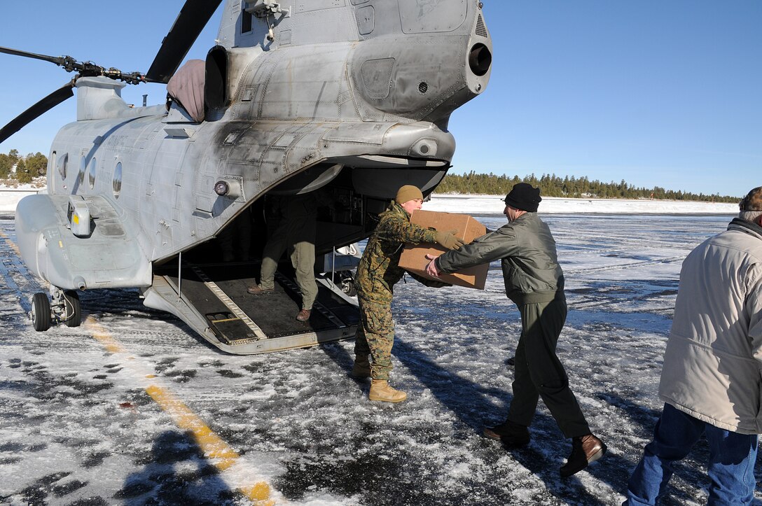 Marines from Marine Medium Helicopter Squadron 764 and other volunteers load toys onto one of the squadron's CH-46E Sea Knight helicopters at the Grand Canyon airport Dec. 15, 2009. The squadron flew into the canyon to bring toys and food to the village of the Havasupai, a Native American tribe living at the bottom of the canyon. The squadron flew into the canyon to bring toys and food to the village for the holidays. The next day, the squadron flew back down to the village to bring the guest of honor, Santa Claus, to the toy giveaway event. The reserve squadron, based at Edwards Air Force Base north of Los Angeles, has flown toys to the village's children for Christmas for the past 14 years.