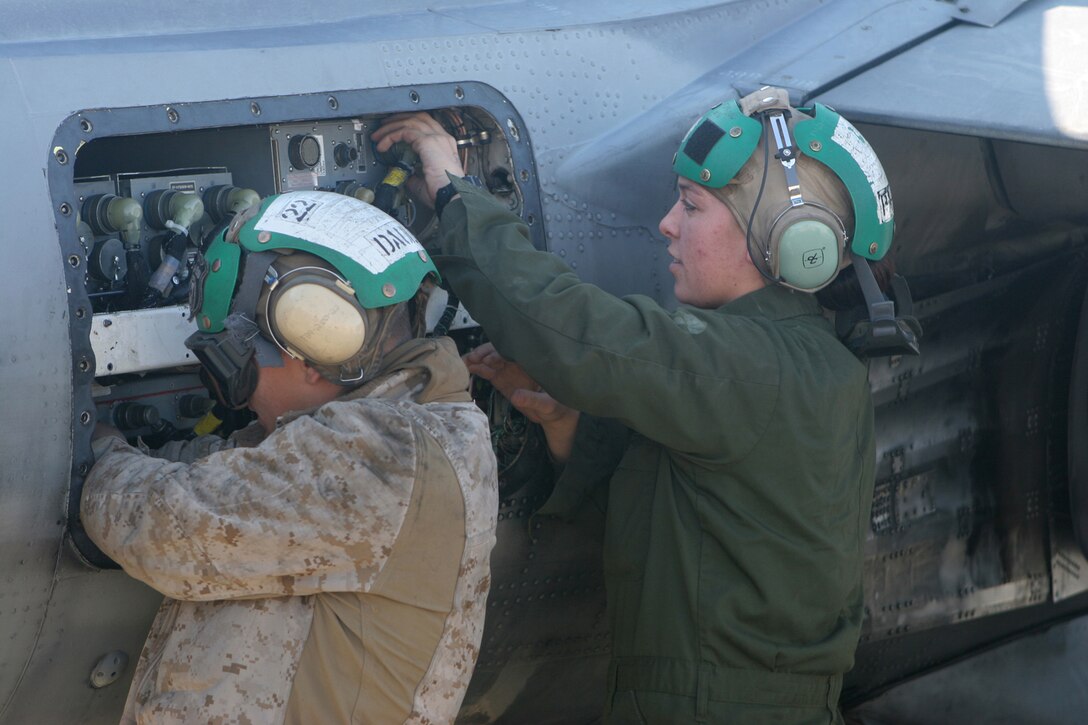 Lance Cpl. Joshua Dault, left, and Cpl. Jessica Pappas, aviation technicians with Marine Attack Squadron 231, Marine Aircraft Group 40, Marine Expeditionary Brigade-Afghanistan, check the left-hand forward panel of an AV-8B Harrier here Dec. 16. (U.S. Marine Corps photo by Lance Cpl. Samuel A. Nasso)