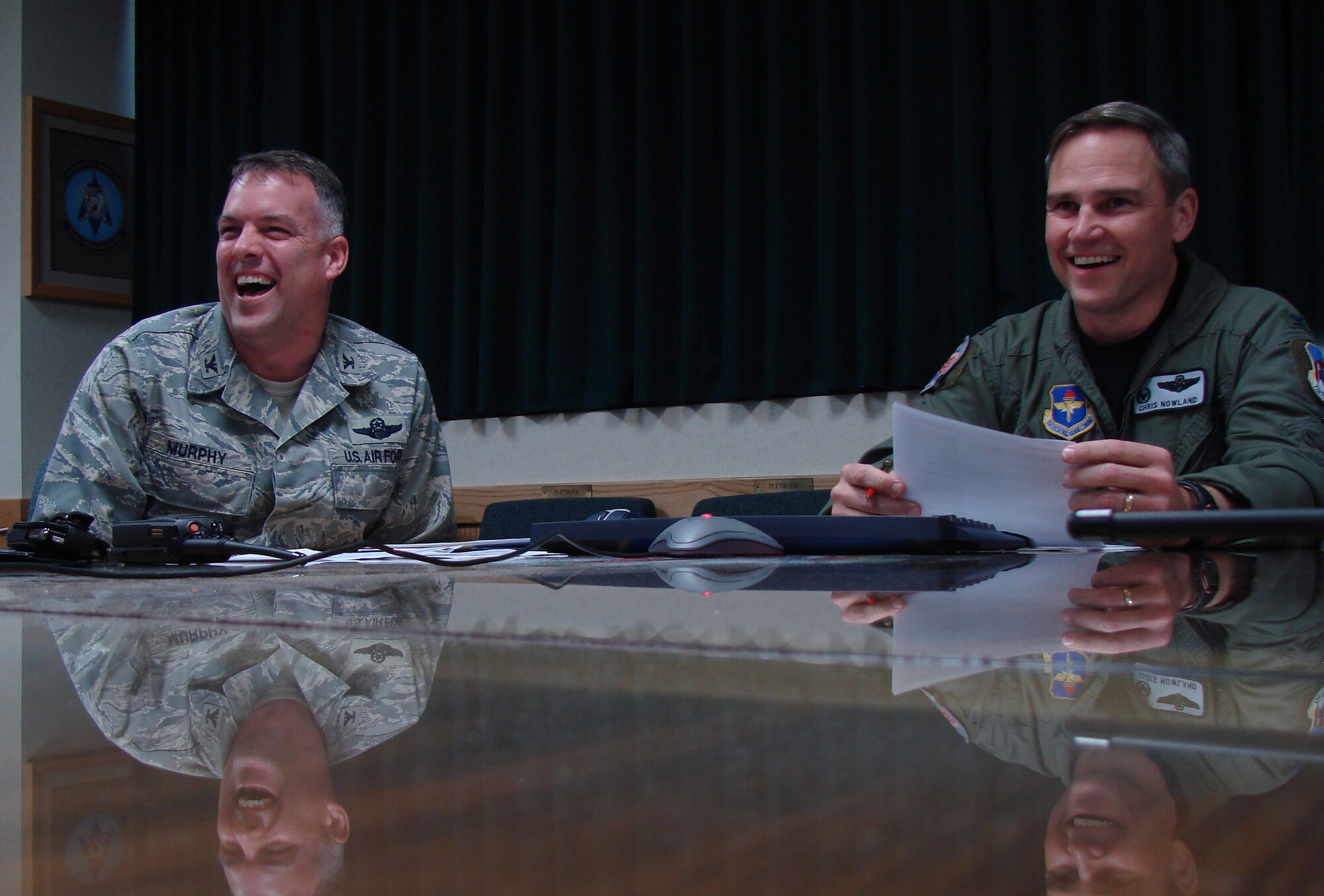 Colonel Chris Nowland, 71st Flying Training Wing commander, and Col. Richard Murphy, vice commander, find humor in the journey of discovery made by officers awaiting Joint Specialized Undergraduate Pilot Training at Vance Air Force Base, Okla. Ten second lieutenants are working with Chad Chambers, audio visual specialist, to create a new graduation dinner video about the adventures of pilot training.