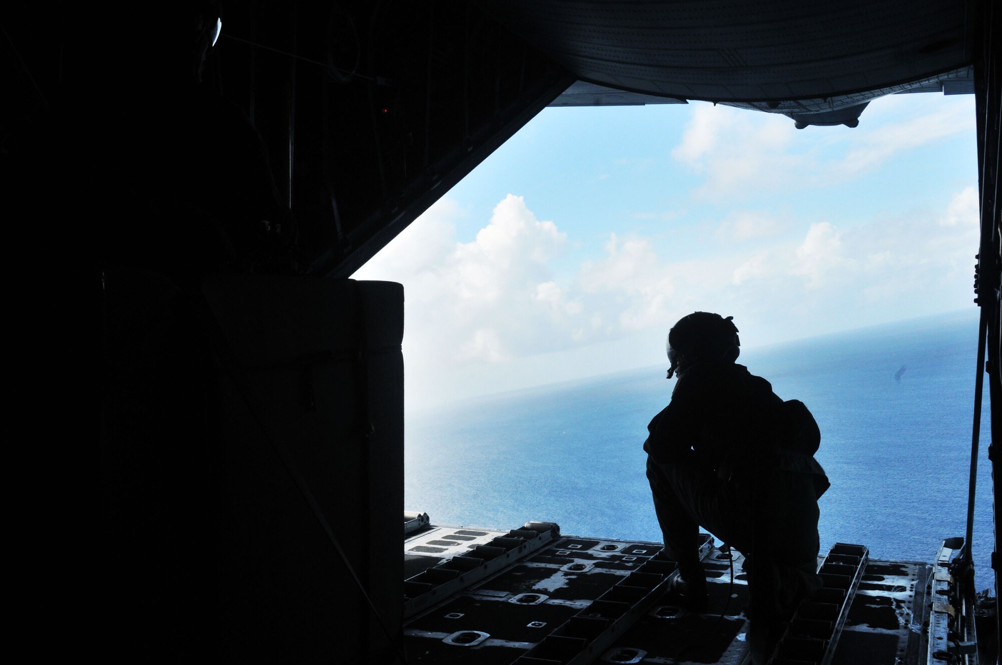 CHUUK ISLANDS - Staff Sgt. Cravenkeo Khamone, 36th Airlift Squadron loadmaster, spots the drop location for a box of donated goods being dropped over the Chuuk Islands Dec. 16 in support of Operation Christmas Drop. The operation, which began in 1952, is the Air Force?s longest-running humanitarian mission. Airmen today continue the tradition delivering supplies to remote islands of the Commonwealth of the Northern Marianas Islands, Yap, Palau, Chuuk and Pohnpei.   (U.S. Air Force photo by Airman 1st Class Julian North)