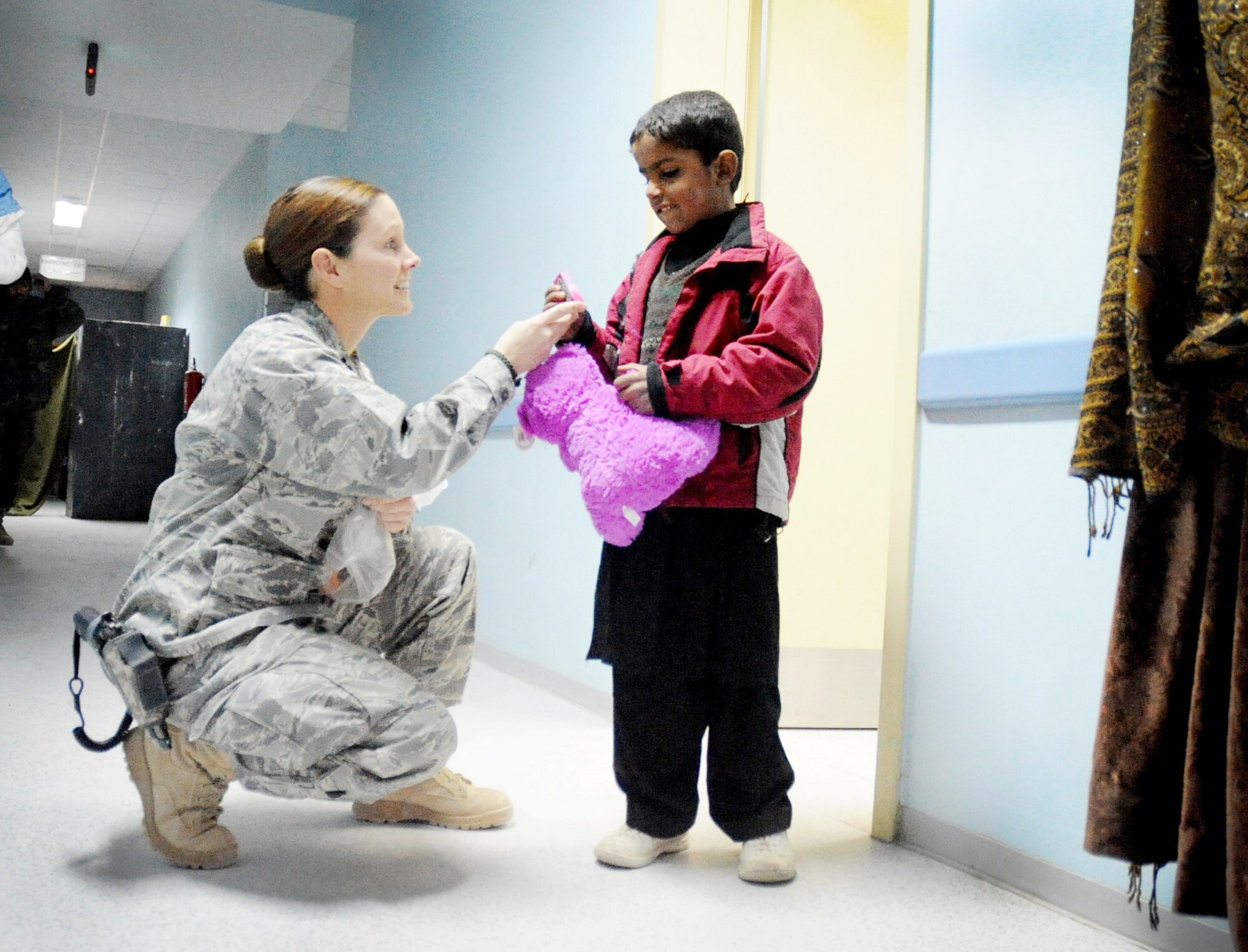 Capt. Tess Marcial hands a toy animal and candies to an Afghan child visiting the Paktya Regional Military Hospital Dec. 14, 2009, at Paktya Province, Afghanistan. The program member's goal is to provide Afghan National Security Forces families with medication, prescriptions, immunizations and health education. Captain Marcial is a Logistics and Patient Administrator. (U. S. Air Force photo/Senior Airman Evelyn Chavez)