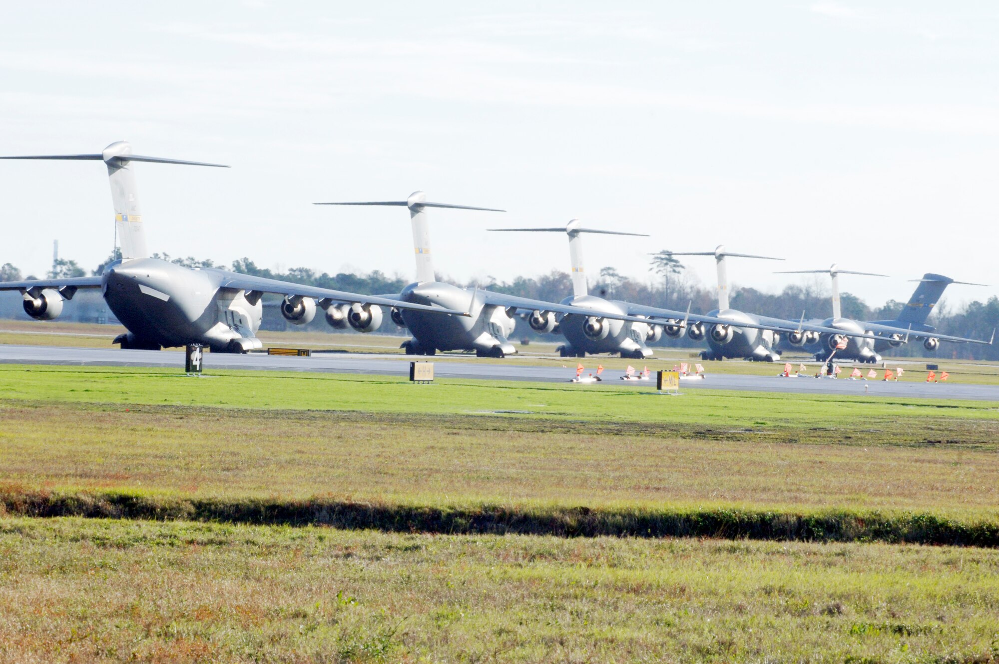 C-17 Globemaster IIIs from Charleston Air Force Base, S.C., line up for take-off in preparation for a strategic brigade airdrop exercise over North Auxiliary Airfield Dec. 16, 2009, near North, S.C. Charleston AFB Airmen conducted a large formation exercise utilizing 10 C-17 aircraft. Soldiers from the 2-319th Airborne Field Artillery, 82nd Airborne Division at Ft. Bragg, N.C., were airdropped along with cargo pallets to simulate the seizure of a remote airfield. (U.S. Air Force photo/Staff Sgt. Marie Brown)
