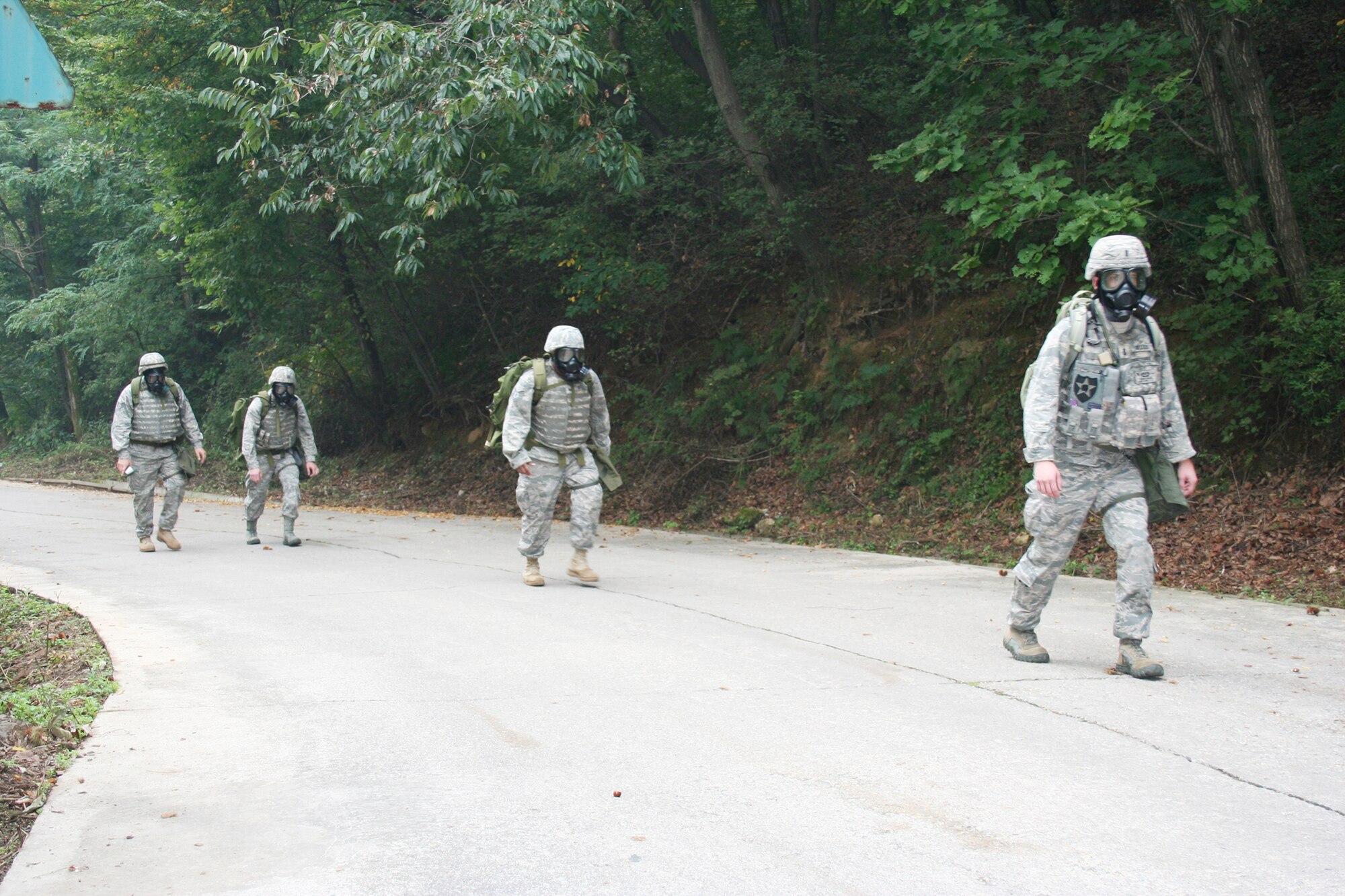 Det. 1 members ascend the hill while wearing their gas masks during a simulated chemical attack during Operation Turbulent Climb Dec. 5 at Camp Red Cloud, Republic of Korea. The exercise trained the Airmen to perform tactical weather tasks in a wartime environment. (U.S. Air Force photo/Tech. Sgt. William Acevedo)