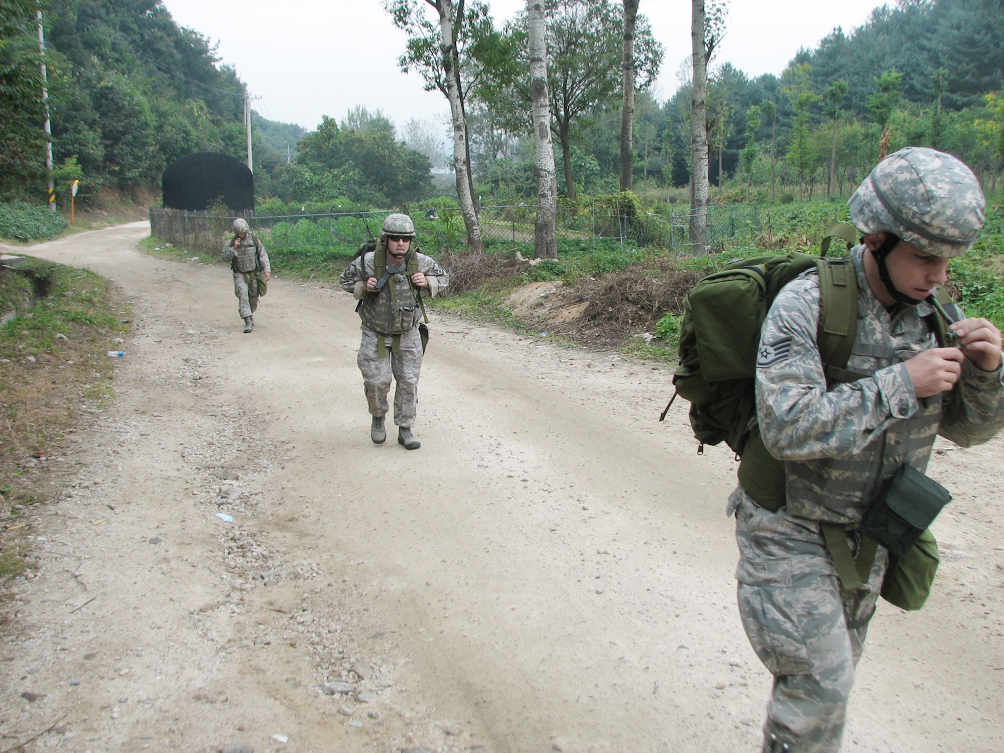 Senior Airman Zach Scott (left to right), Master Sgt. Geoffrey Mason and Staff Sgt. Billy Harris make their way up the hill Dec. 5 near Camp Red Cloud, Republic of Korea during Operation Turbulent Climb. The team members ascended more than 1,000 feet while carrying 65 pounds of gear and covering nearly five miles in distance. The Airmen are assigned to the Det. 1, 607th Weather Squadron. (U.S. Air Force photo/Tech. Sgt. William Acevedo) 