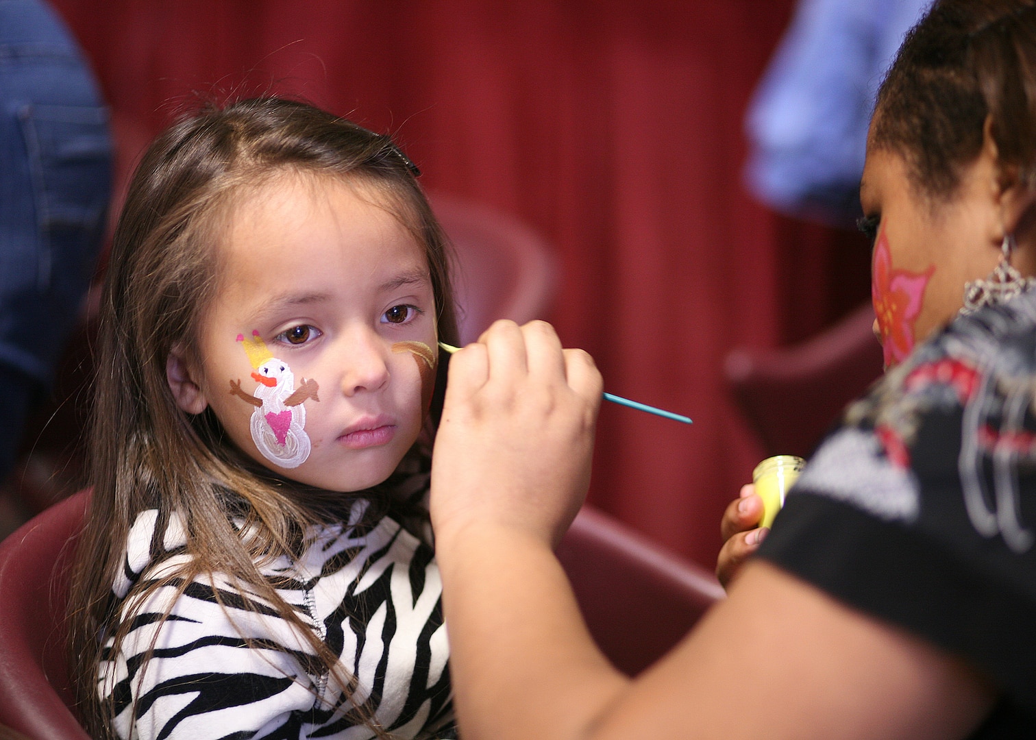 Mikayla, daughter of 2nd Lt. Mary O'Donnell, 59th Medical Operations Group, gets her face painted at the Skylark Community Center Dec. 12. (U.S. Air Force photo/Robbin Cresswell) 